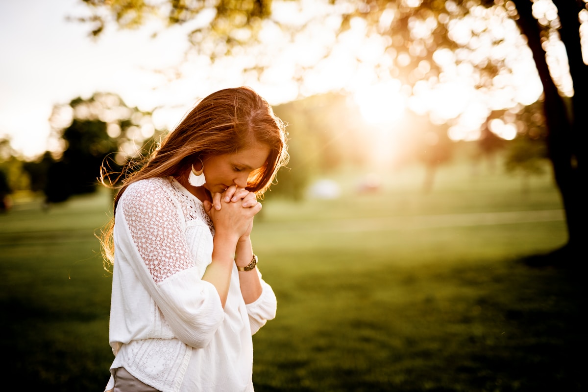 A woman pausing in quiet contemplation at home.