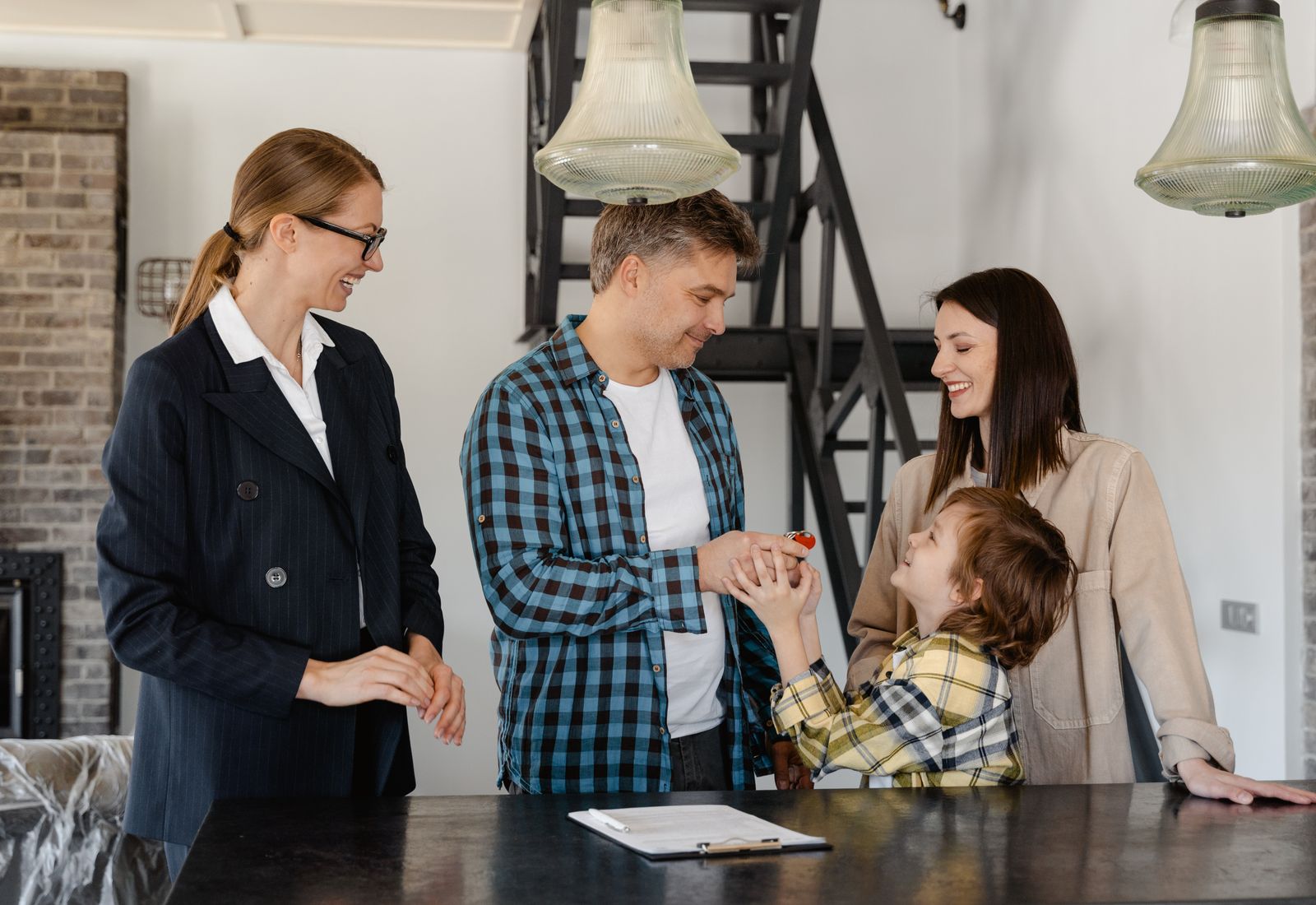 A real-estate agent handing keys to a family in their new home